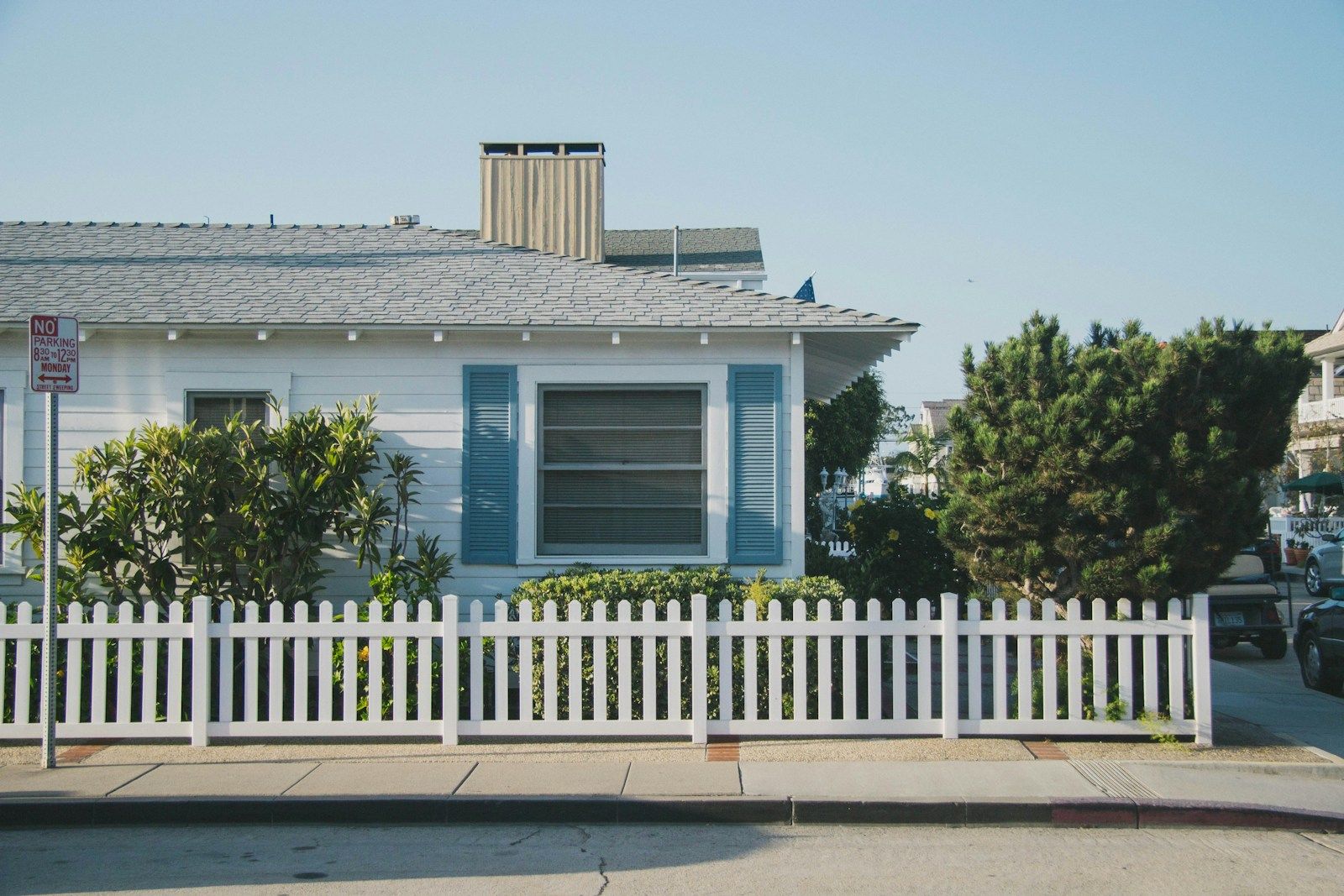 Single-story bungalow behind a white picket fence