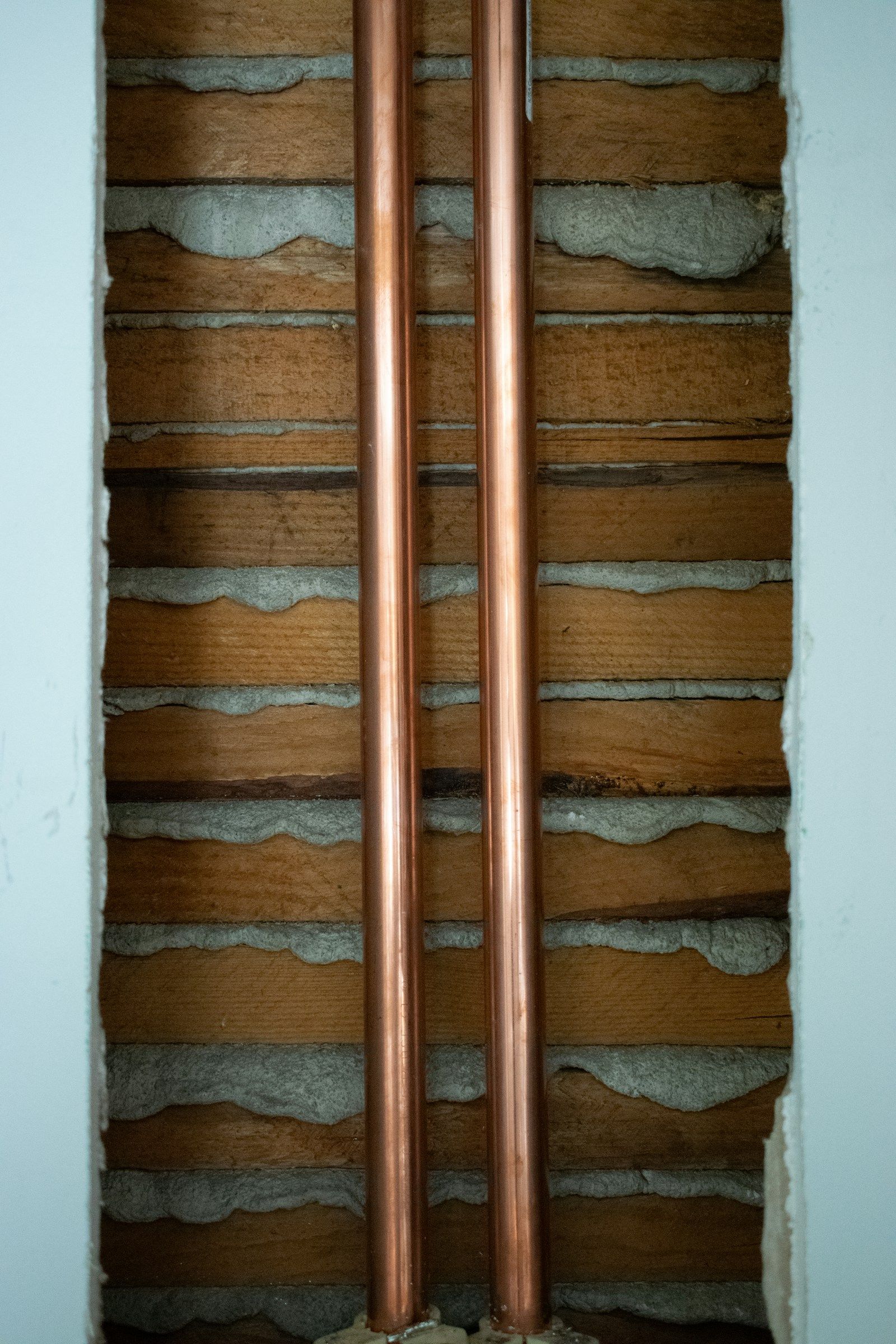 Two new copper water lines running up through an open wall cavity