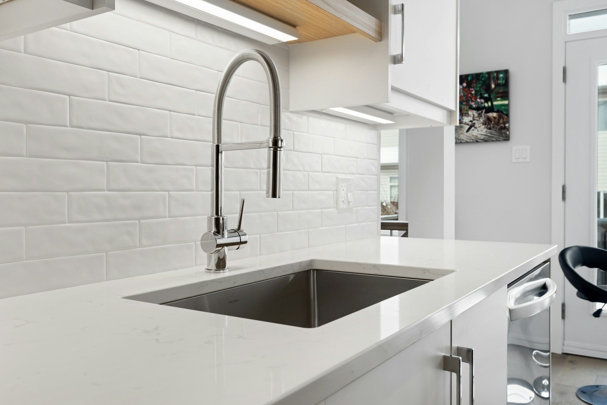 Stainless steel kitchen sink with a tall pull-down faucet
